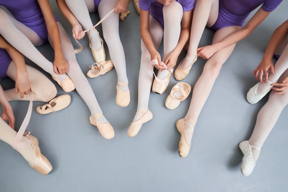 This image shows ballet dancers putting on their ballet slippers.